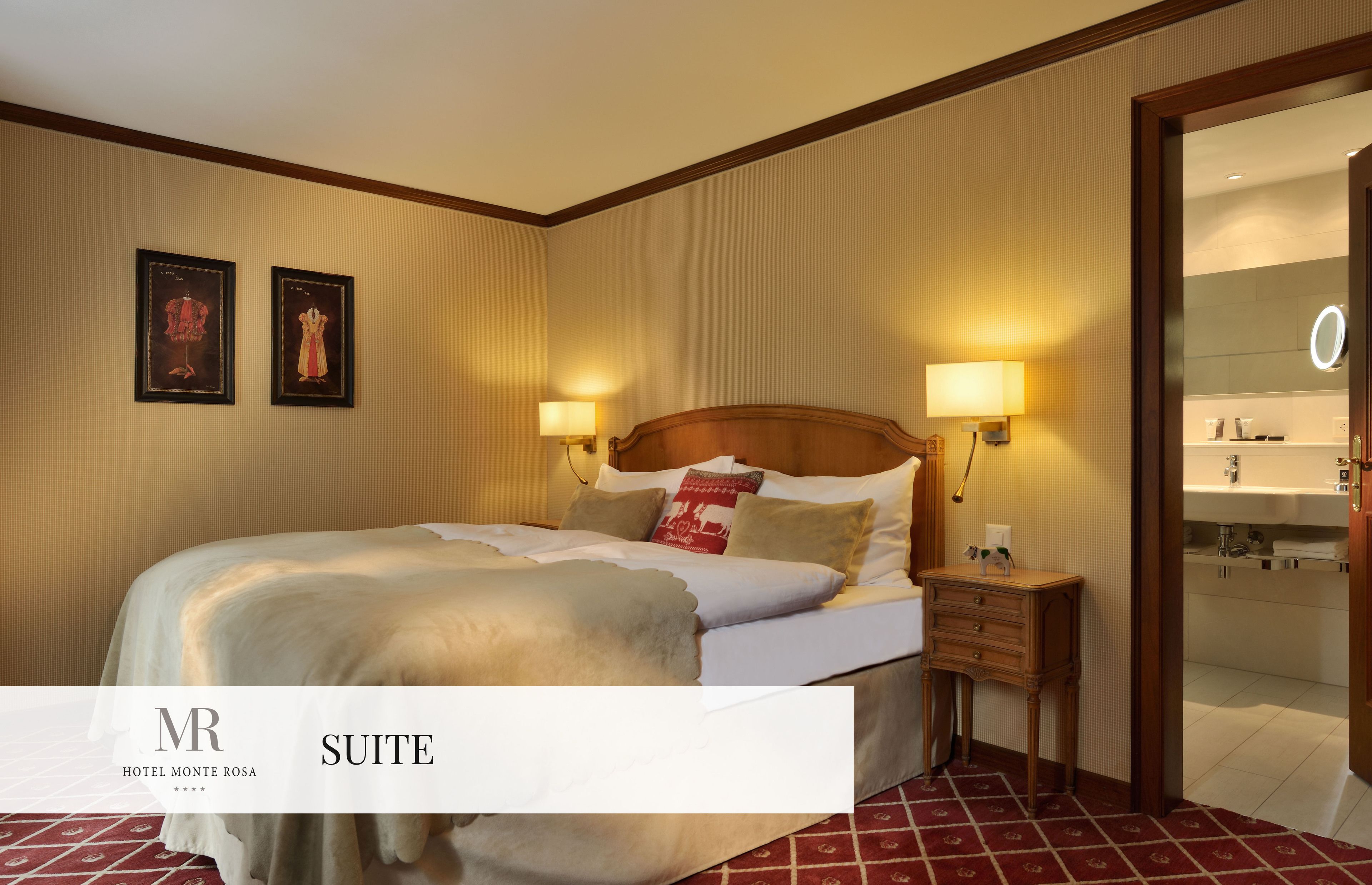 A hotel suite with a bed, bedside lamps, a nightstand, and a view into the bathroom.