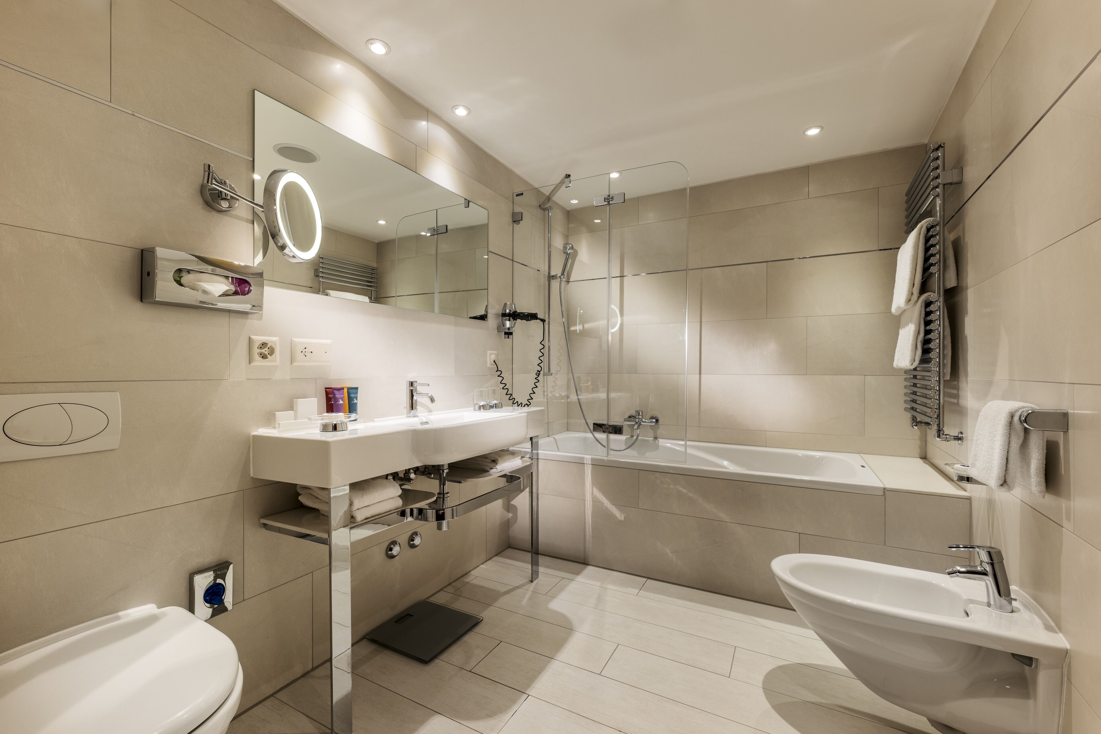 Une salle de bain moderne avec un lavabo, un miroir et une baignoire.