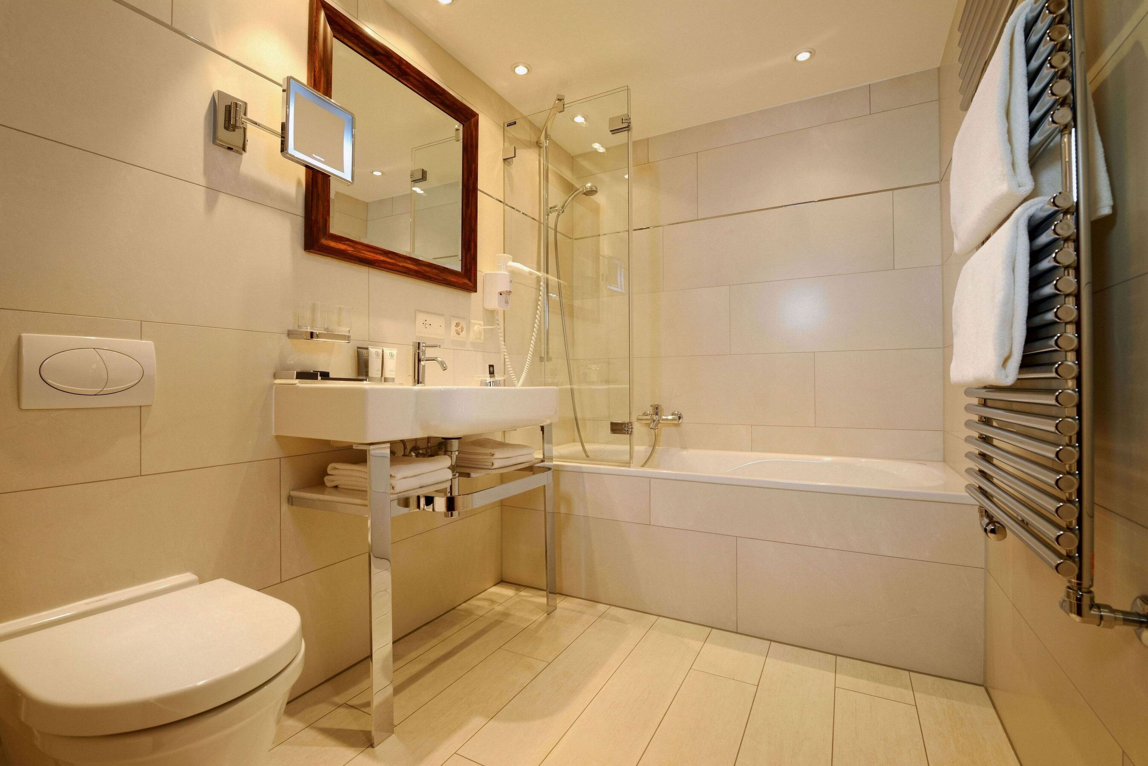 Un bagno moderno con doccia vetrata, un lavandino bianco e una vasca da bagno.