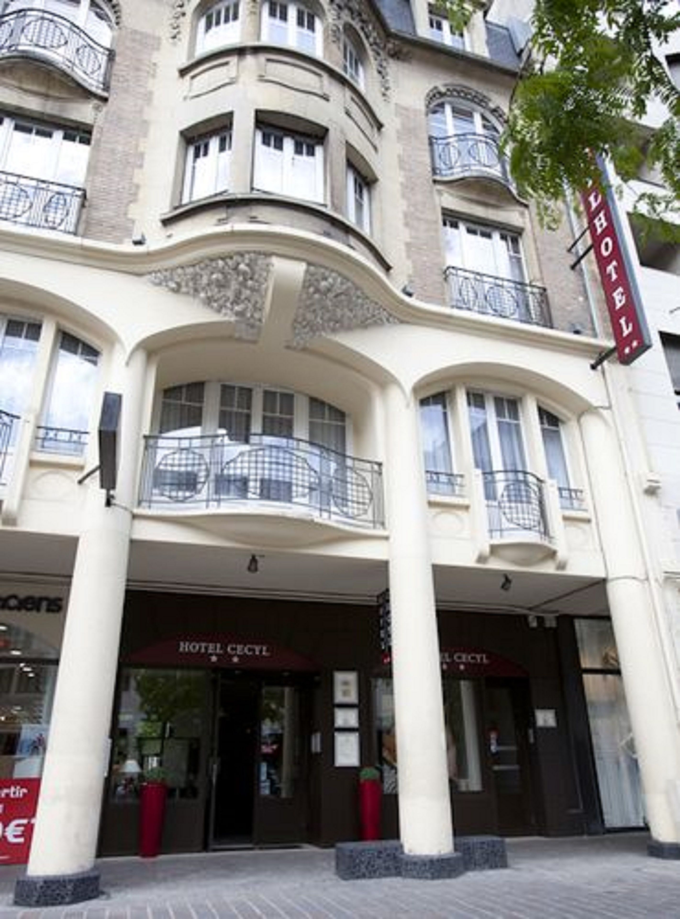 A hotel with a classic architectural style, featuring a prominent entrance with a balcony.
