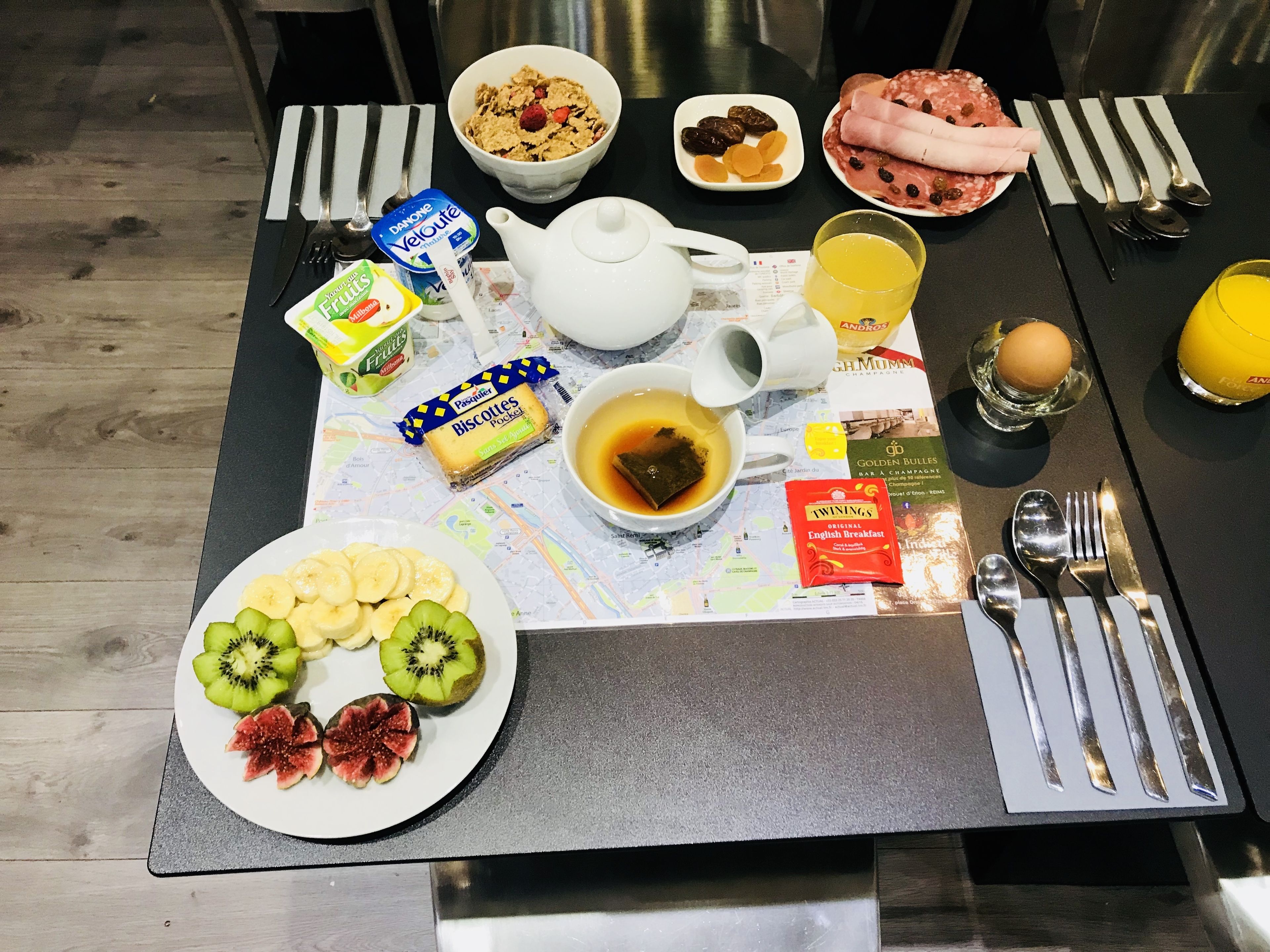 Una mesa de desayuno con diversas opciones de comida, como frutas, pasteles y bebidas.