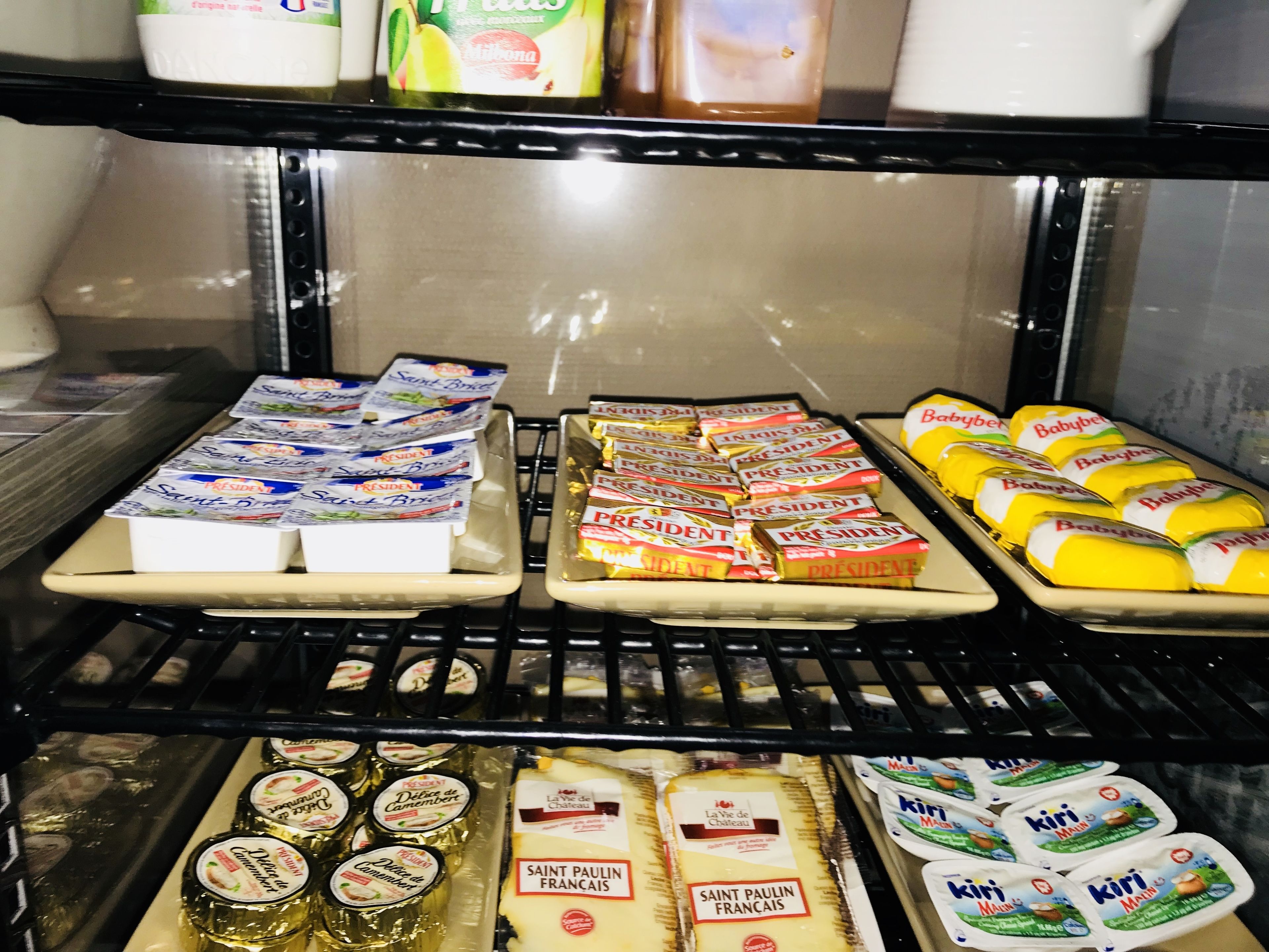 Mostrador refrigerado con diversos productos lácteos, como yogures, quesos y mantequilla.