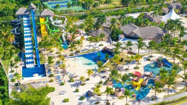 A resort with a large pool, water slides, palm trees, and thatched-roof structures. - Royalton Splash Punta Cana, An Autograph Collection All-Inclusive Resort & Casino (Punta Cana)