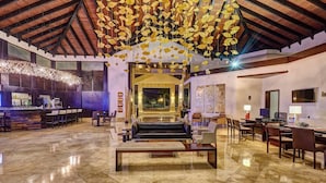 A spacious lobby with a marble floor, a reception desk, seating area, and a large chandelier. - Royalton Splash Punta Cana, An Autograph Collection All-Inclusive Resort & Casino (Punta Cana)
