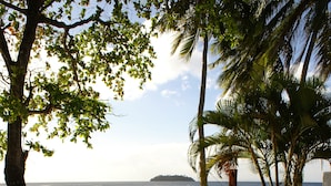 Zona junto a la piscina con sillones de descanso y una piscina, con vistas al mar.