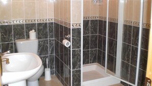 A bathroom with a toilet, bidet, and shower stall.