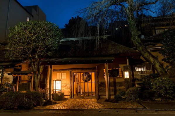 A traditional Japanese building with a wooden entrance, stone pathway, and a lantern. - Yamagaso (Hakone)