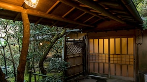 A traditional Japanese gate with a wooden structure and a bamboo fence.