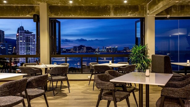 En restaurant med udsigt til en bys skyline i skumringen.
