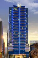 Un hotel moderno y alto, con una entrada principal y varios pisos.