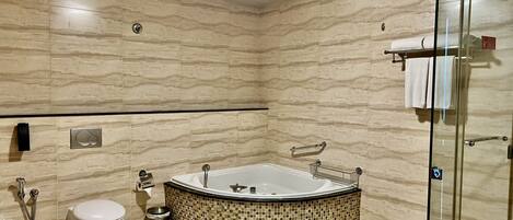 A modern bathroom with a freestanding bathtub, a toilet, and a glass shower enclosure.