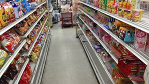 A supermarket aisle with various snack and food products on shelves. - Towadako Backpackers (Towada)