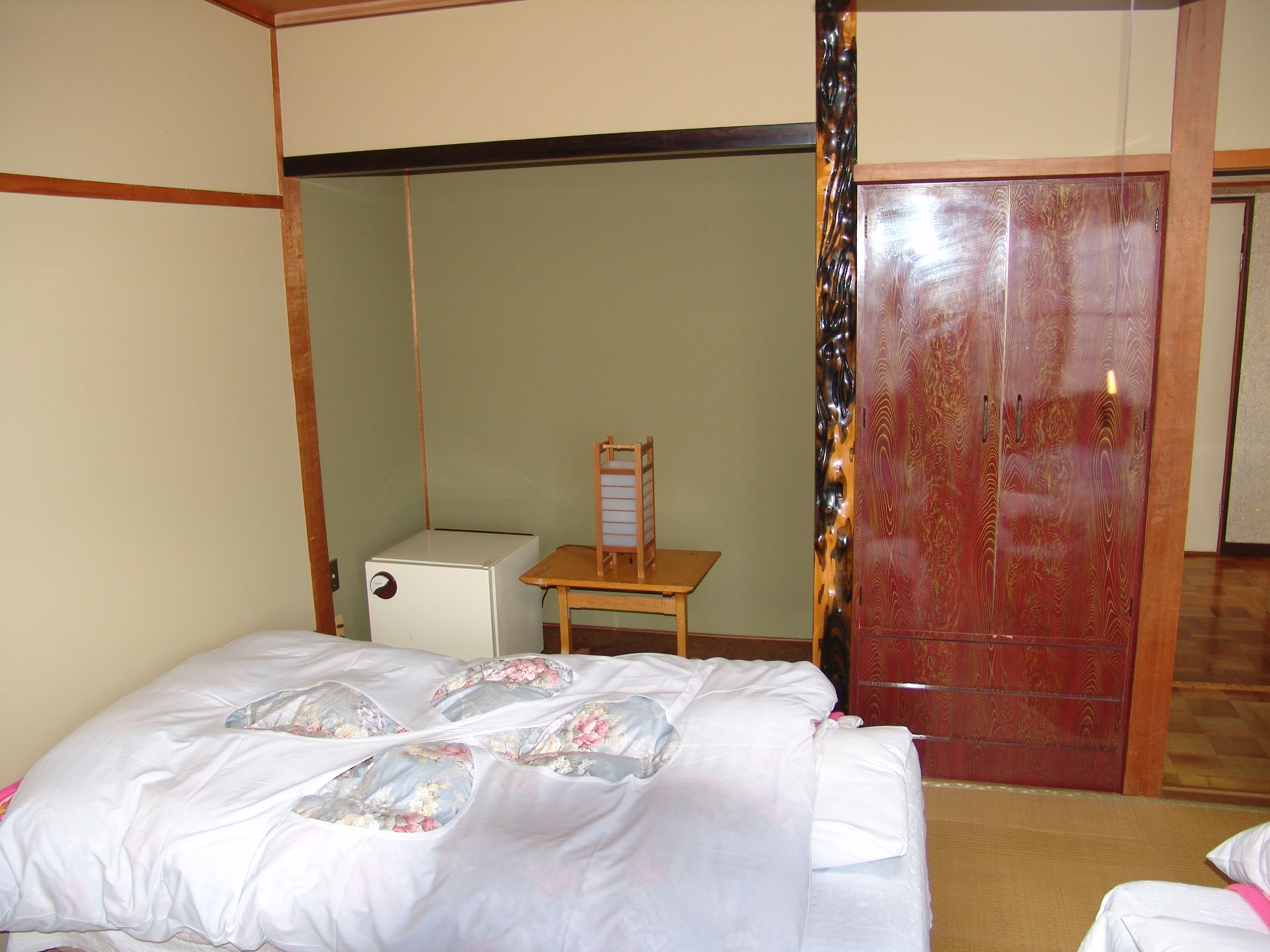 A room with a bed, a small table, and a wardrobe.