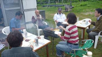 Un grupo de personas reunidas alrededor de una parrilla al aire libre.