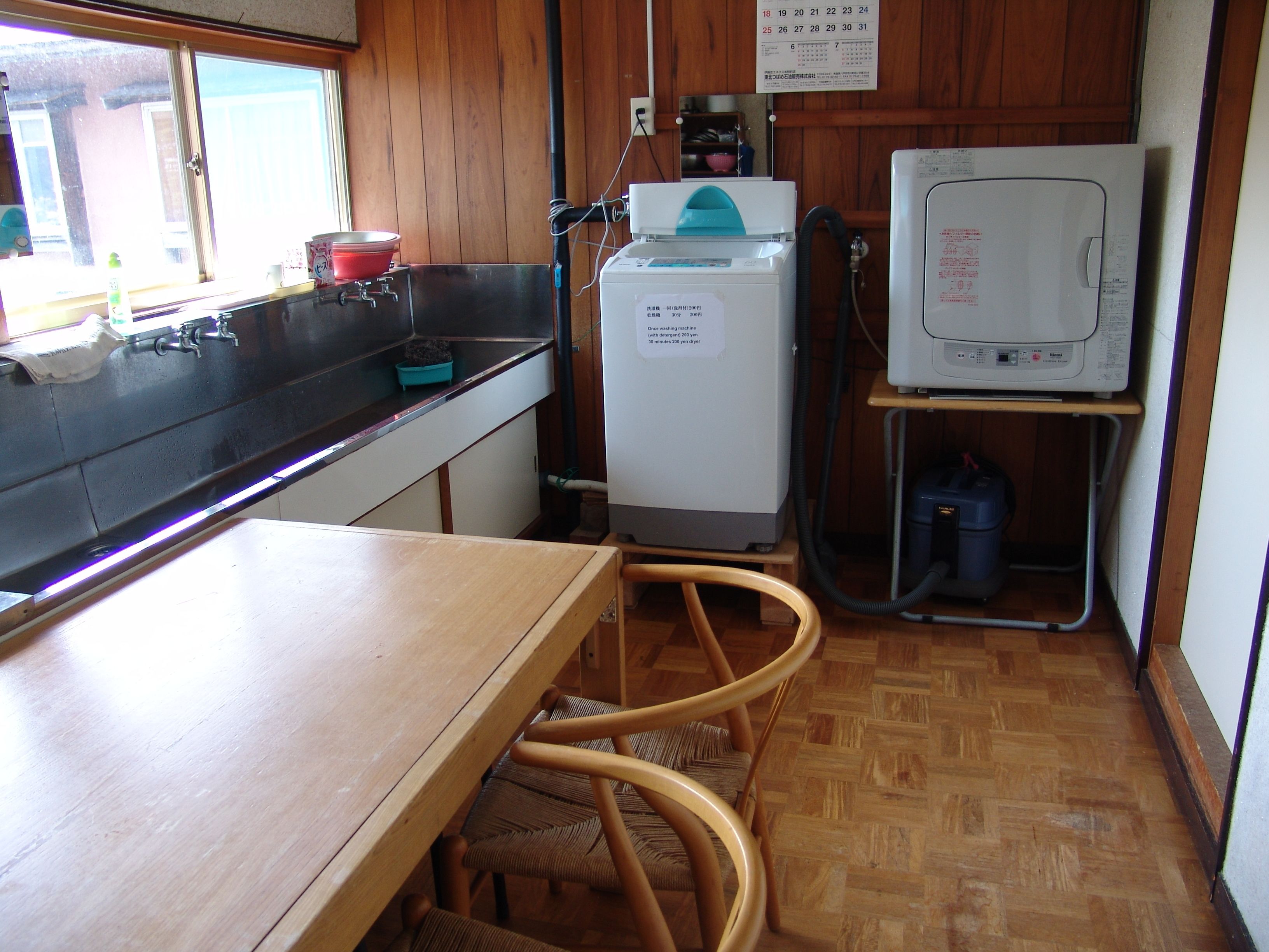 Una cocina compacta con un lavamanos, lavadora y un refrigerador pequeño.