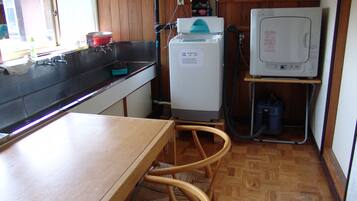 Una cocina compacta con un lavamanos, lavadora y un refrigerador pequeño.