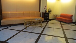 Ein Wohnzimmer mit einer Couch, einem Couchtisch und einem Ventilator.