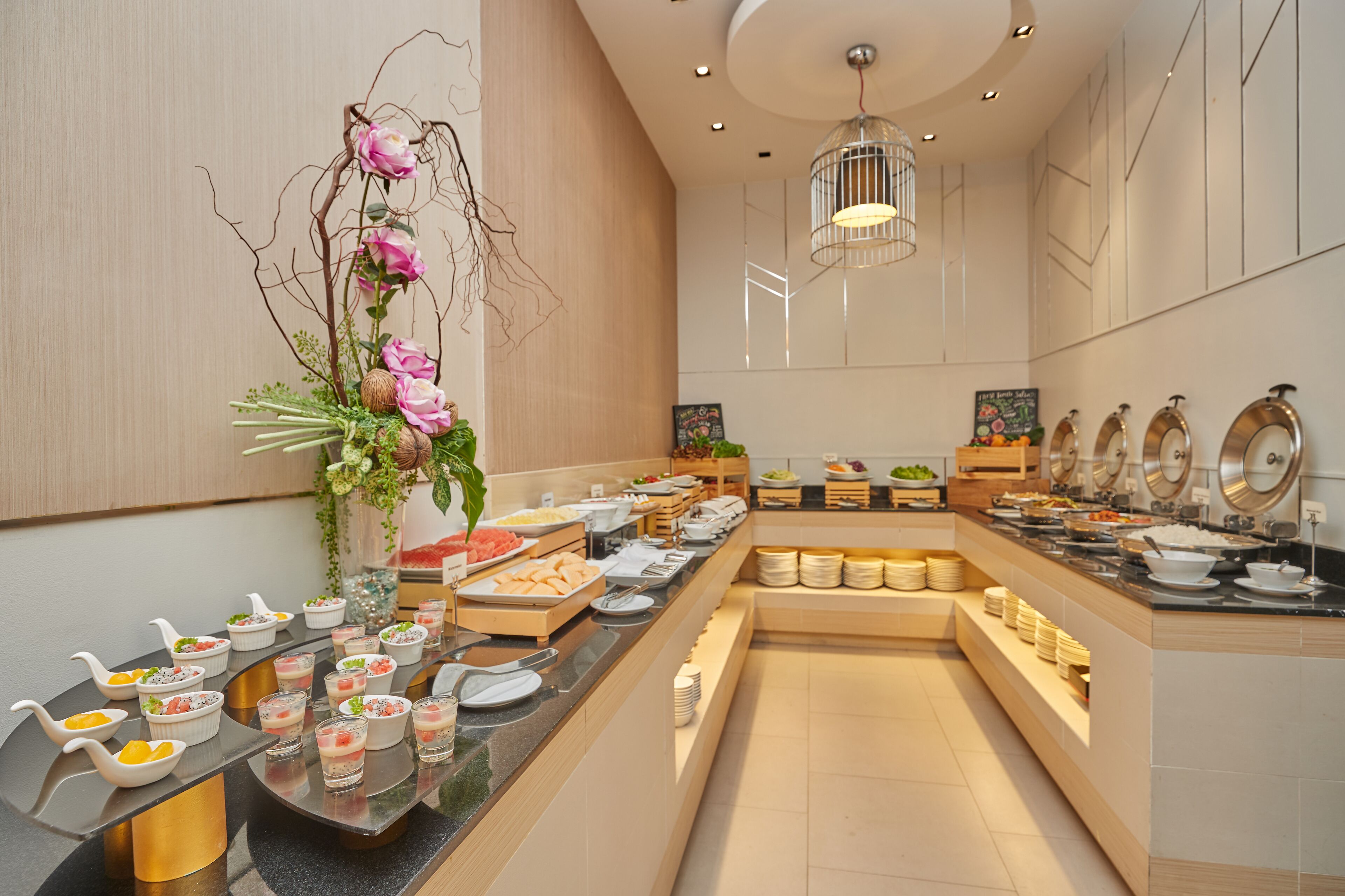 A buffet setup with various food items and a decorative floral arrangement.