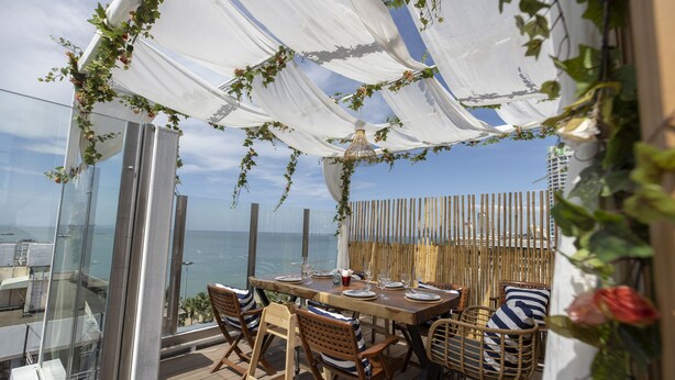 A wooden deck with a table set for dining, overlooking the sea. - Pattaya Sea View Hotel (Pattaya)