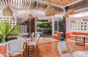 Un interior moderno con muebles de mimbre, piso a cuadros y vistas al exterior.