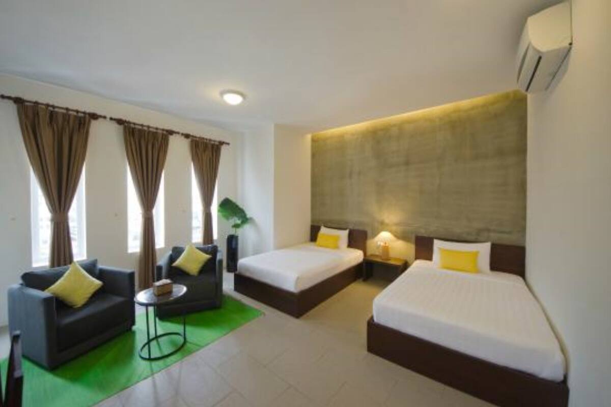 Habitación de hotel con dos camas, un sofá, una mesita y cortinas.