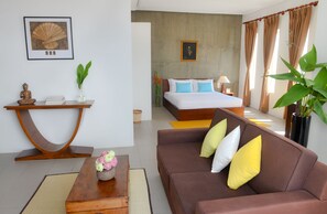 A modern hotel room with a bed, a sofa, a console table, and a large plant.