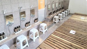A modern bathroom with multiple sinks, mirrors, and toiletries. - Star Capsule Okinawa (Naha)