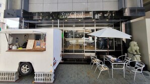A food truck named 'Star Capsulf' parked outside a building with a glass storefront. - Star Capsule Okinawa (Naha)