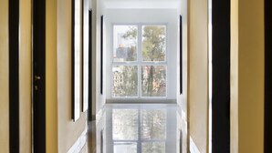 A hallway with a large window at the end, leading to a view of trees and buildings. - Amaris Hotel Dr. Susilo Grogol (Jakarta)
