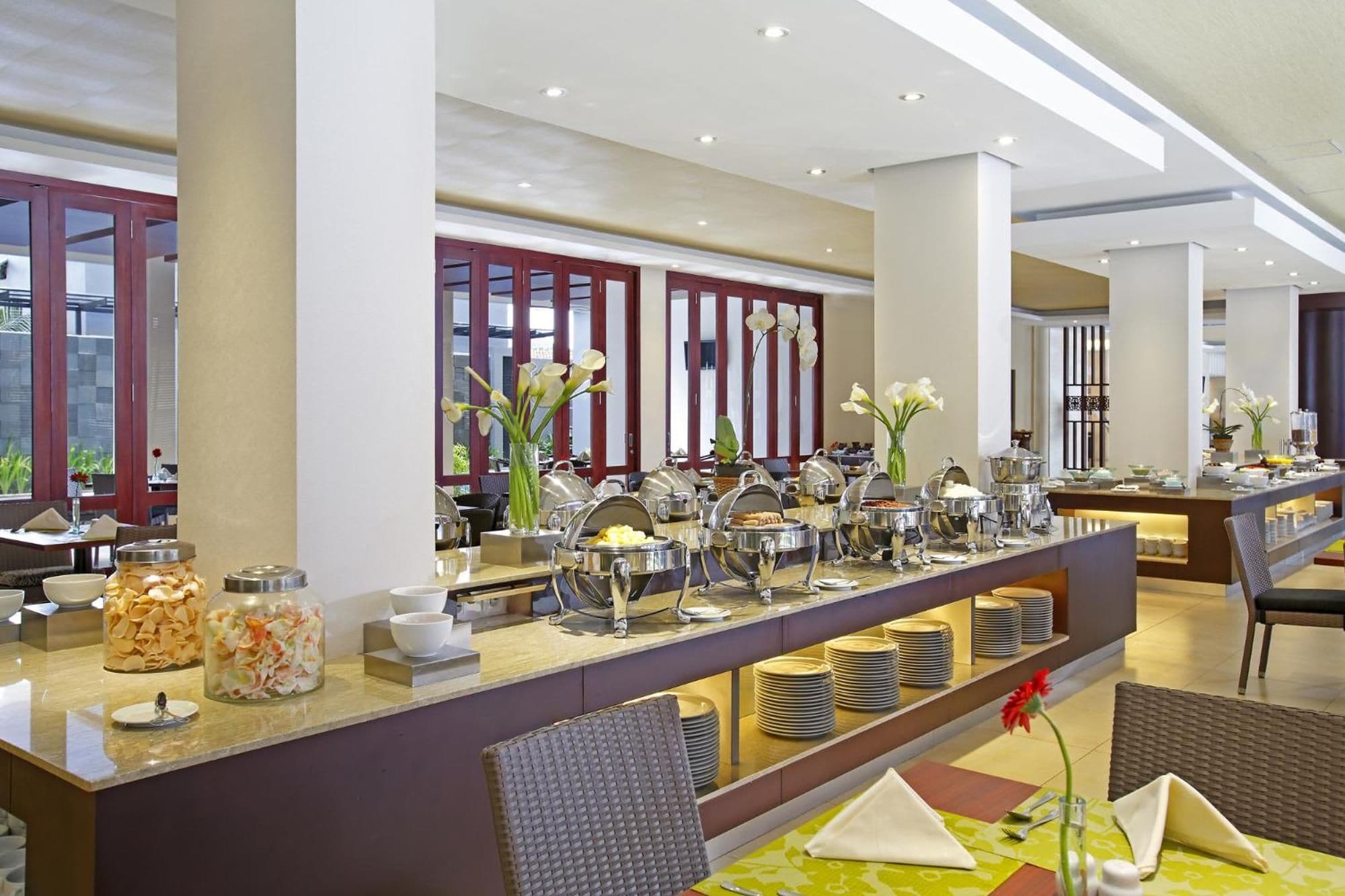 Montaje tipo buffet con diversas opciones de comida y una zona de estar con sillas y mesas.