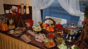 Uma mesa de buffet com diversos alimentos e acompanhamentos.