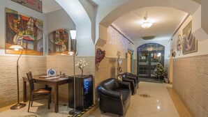 A lobby with a reception desk, seating area, and a Christmas tree.