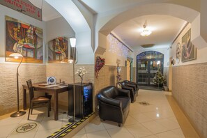 A lobby with a reception desk, leather sofas, and a Christmas tree. - Antica Residence (Kraków)