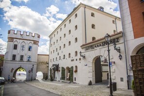 Un edificio storico con una torre, finestre ad arco e un cartello che indica un hotel.