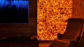 Una spa con parete in legno, parete in pietra con motivo a mosaico e una poltrona reclinabile.