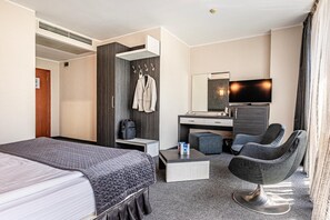 A hotel room with a bed, a desk, a chair, a television, and a wardrobe. - Hotel Noris (Plovdiv)