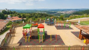 Un terrain de jeux doté de diverses installations et offrant une vue sur le paysage environnant.
