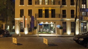 A multi-story hotel with a central entrance, balconies, and a sign indicating it is a hotel.