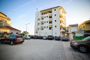 A multi-story parking garage with several cars parked. - Iliria International (Durrës)