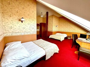 A hotel room with two beds, a desk with a chair, a wardrobe, and a small desk lamp. - Pa Nska Gv Ra (Jaworzno)