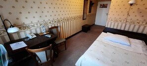 A hotel room with a bed, a desk with a telephone, a chair, a lamp, and a mirror. - Pa Nska Gv Ra (Jaworzno)