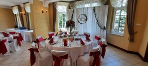 A banquet hall with round tables set for a formal event, featuring white tablecloths and red sashes. - Pa Nska Gv Ra (Jaworzno)