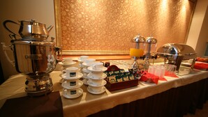 A buffet setup with a coffee maker, tea pots, and a variety of food items. - Hotel Seven 7 (Kalisz)