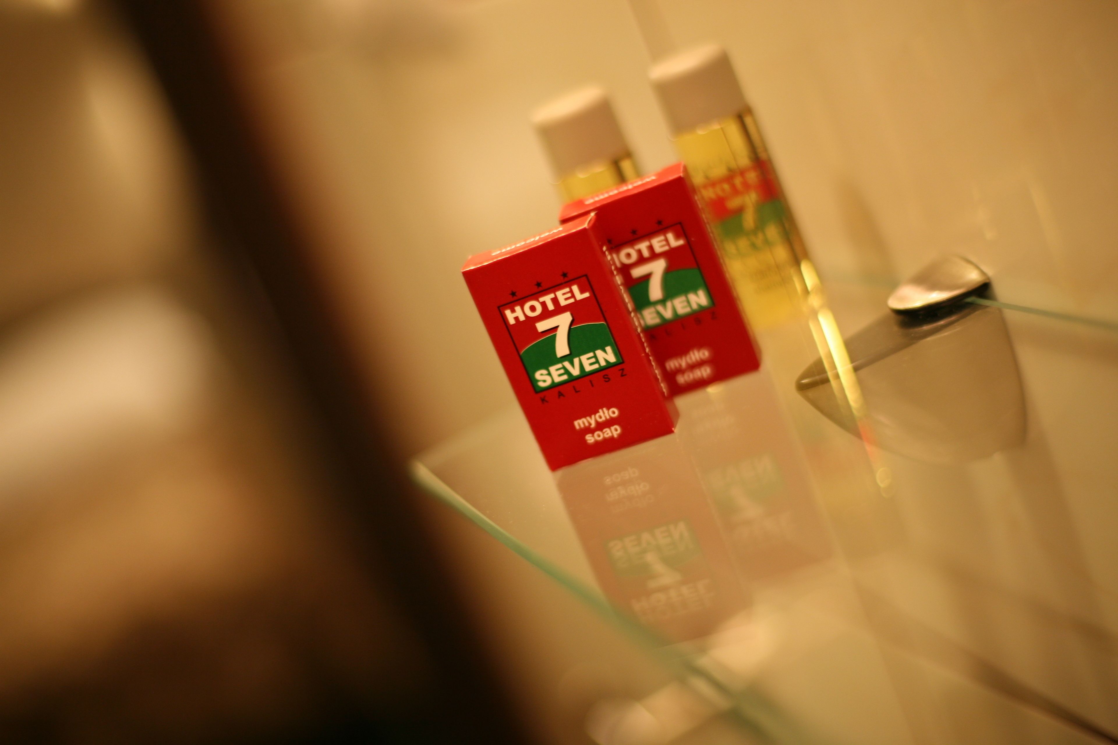 A bathroom with Hotel 7 Seven toiletries on a glass shelf.