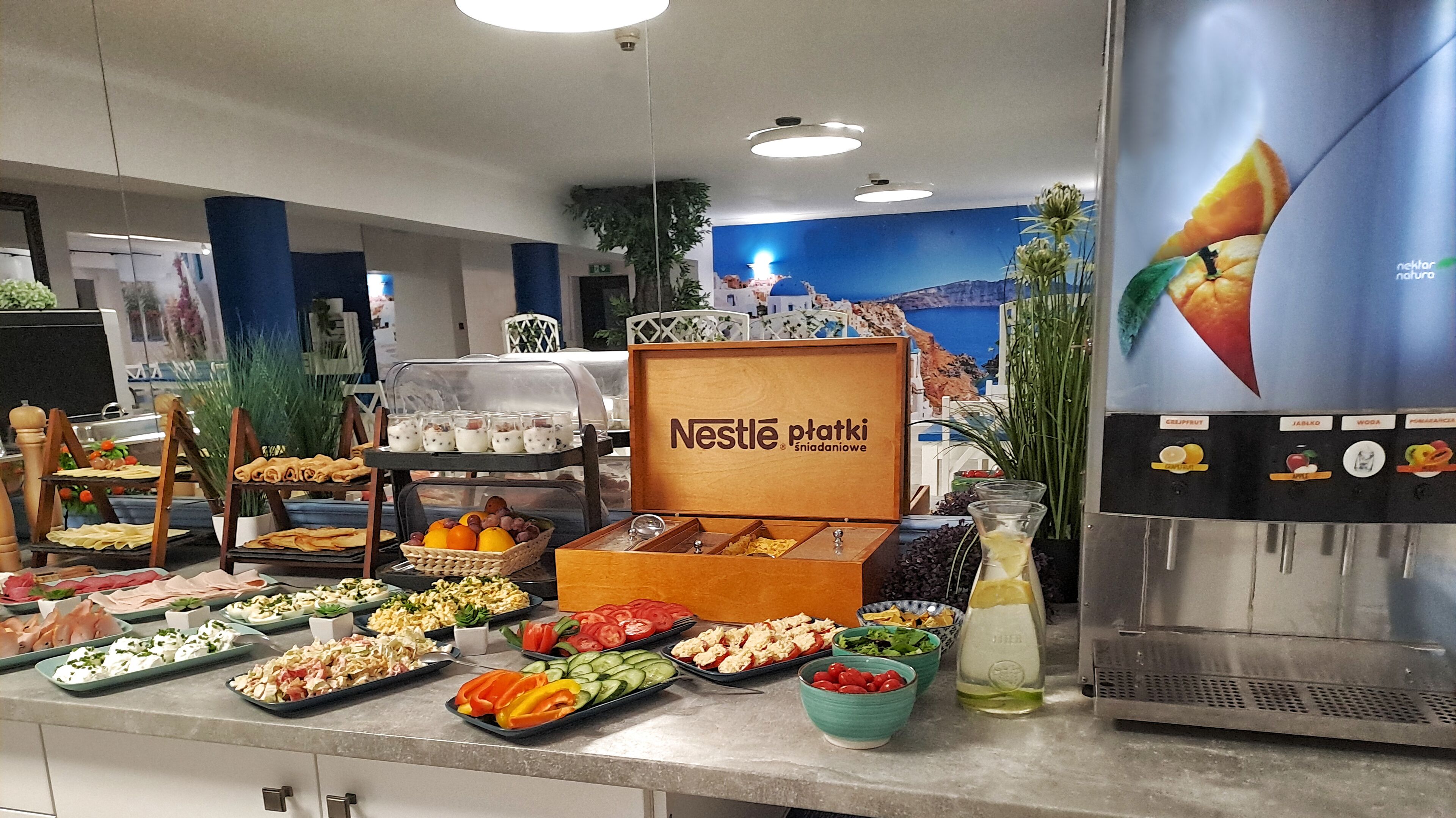 A buffet area with various food items and a Nestlé p'taki display.