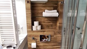 A modern bathroom with a wooden wall, a glass shower enclosure, and a toilet.