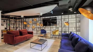 Un interior moderno con un sofá rojo, un sofá azul y una mesa de centro.