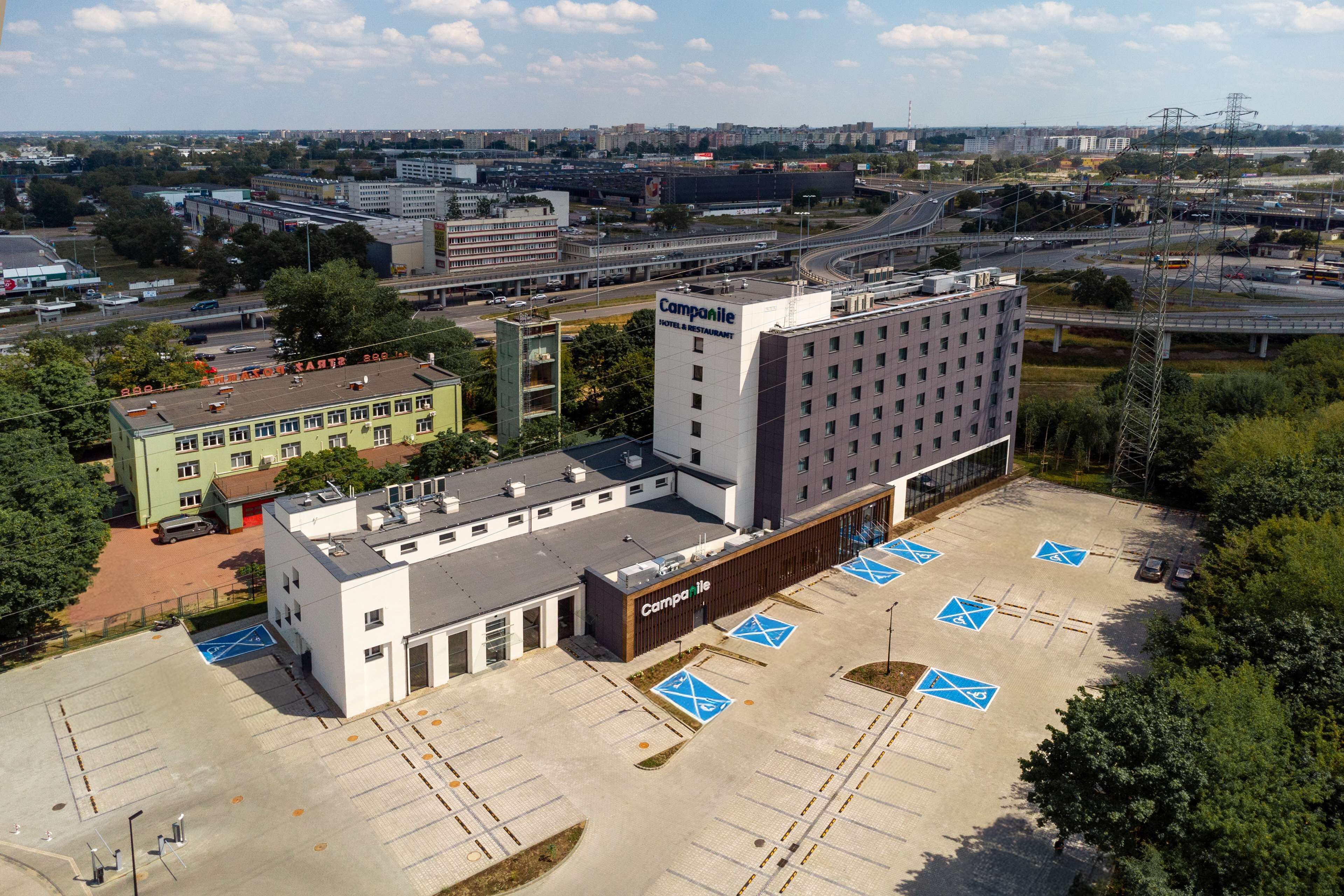 Un hôtel à étages, un parking comprenant des places réservées aux personnes handicapées et offrant une vue sur les environs urbains.