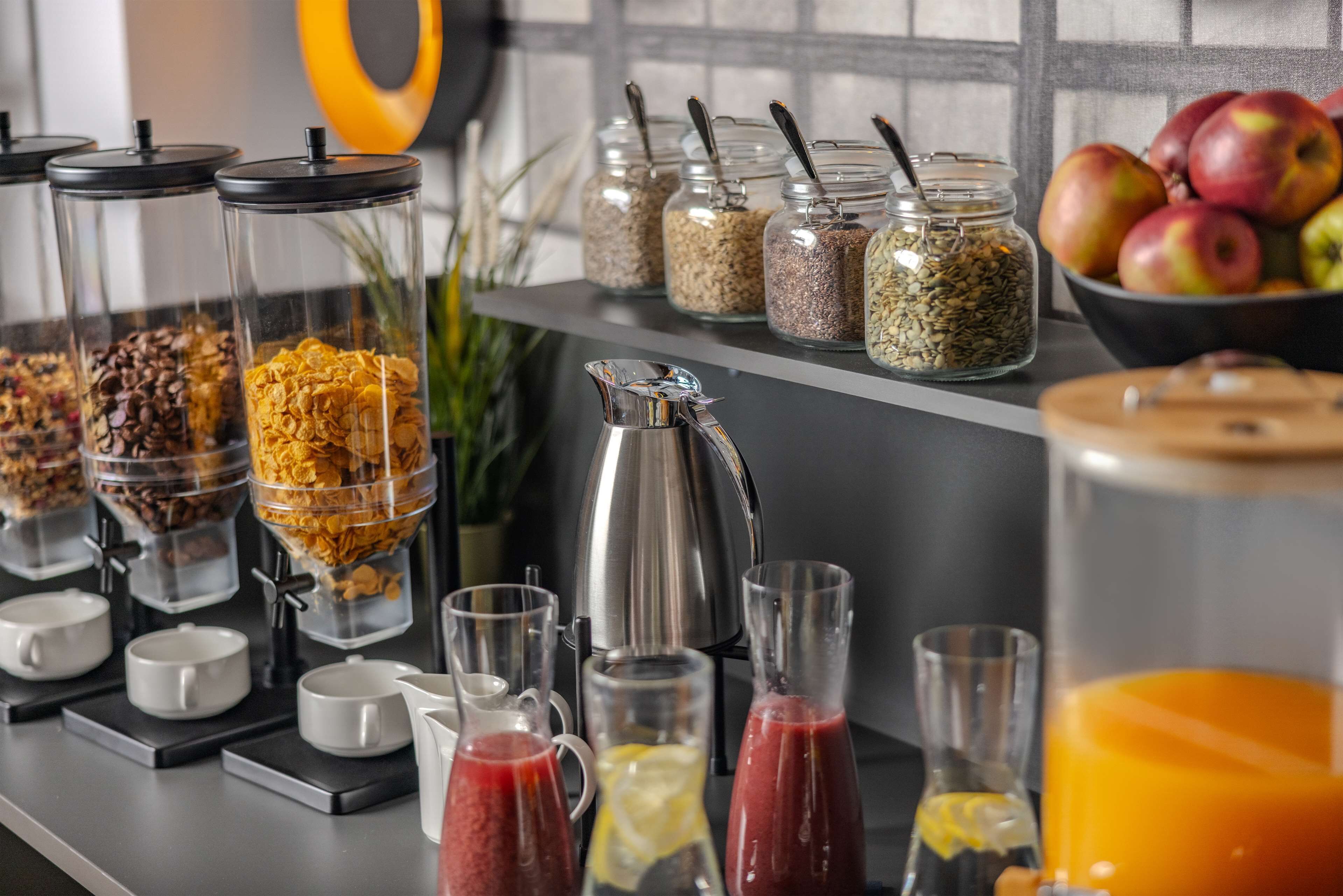 Un bufé de desayuno con diversas opciones de comida, como cereales, granola y frutas frescas.