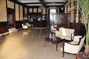 A lobby with a reception desk, seating area, and a bar.